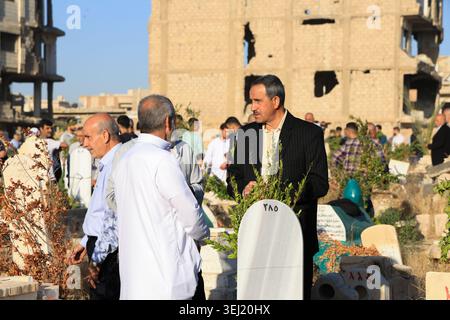 DAMASKUS, SYRIEN - 27. MAI 2026: Syrische Familien besuchen einen örtlichen Friedhof, um Verwandte zu ehren und zu betrauern, die am ersten Tag von Eid al-Adha im Stadtteil Jobar getötet wurden. Verwandte versammeln sich um die Gräber inmitten der umliegenden Kriegsruinen, um für ihre Lieben zu beten. Stockfoto