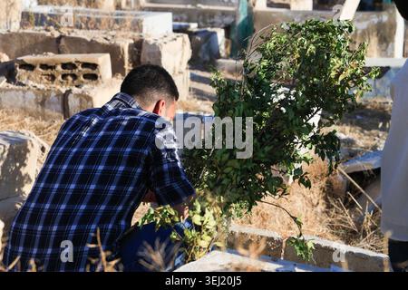 DAMASKUS, SYRIEN - 27. MAI 2026: Syrische Familien besuchen einen örtlichen Friedhof, um Verwandte zu ehren und zu betrauern, die am ersten Tag von Eid al-Adha im Stadtteil Jobar getötet wurden. Verwandte versammeln sich um die Gräber inmitten der umliegenden Kriegsruinen, um für ihre Lieben zu beten. Stockfoto
