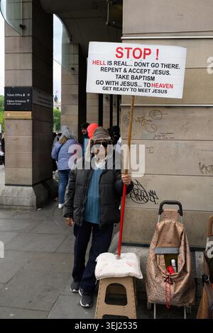 London, Großbritannien. 16. Mai 2026. Ein christlicher Straßenprediger mit einem Plakat vor der Westminster U-Bahnstation. Stockfoto