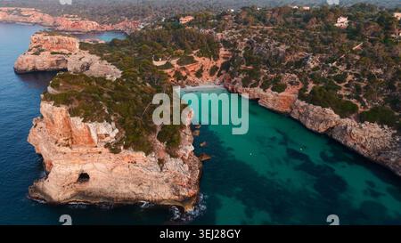 Cala des moro Beach, mallorca, türkisfarbenes Wasser und felsige Klippen bei Sonnenuntergang Stockfoto