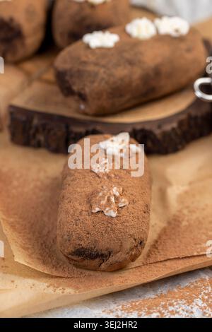 Braune Teigkartoffeln liegen auf Servierbrett und Papier, süßer klassischer Kuchen aus Butter und eine große Menge Kakao gemischt mit Biskuitkuchen und Co Stockfoto