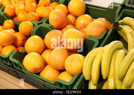 Frische Orangen und Bananen auf dem Hintergrund des Lebensmittelmarktes. Gesunde Fruchtauswahl für Shopping-Ernährung Wellness- und Diätkonzepte. Stockfoto