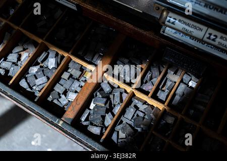 Vintage-Buchdruckblöcke aus Metall, die in einer Holzschublade angeordnet sind Stockfoto