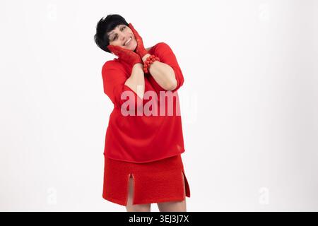 Junge Frau, die ihr Gesicht spielerisch mit Händen bedeckt Stockfoto