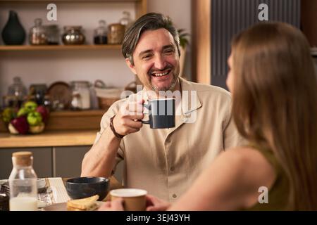 Mann trinkt Kaffee während einer zwanglosen Frühstückssitzung Stockfoto