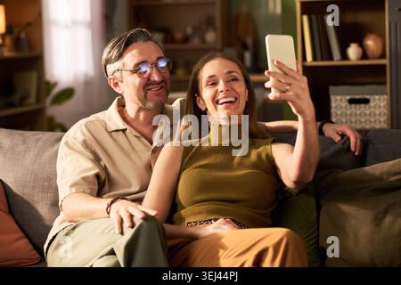 Erwachsenes Paar nimmt zu Hause ein Smartphone-Selfie für soziale Medien auf Stockfoto