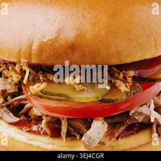 Essen, Ein frisch zubereitetes Sandwich mit feinem Schweinefleisch, mit zartem Fleisch, knusprigen Zwiebeln, Gurken und Tomaten in einem weichen Brötchen. Dieses leckere Gericht ist perfec Stockfoto
