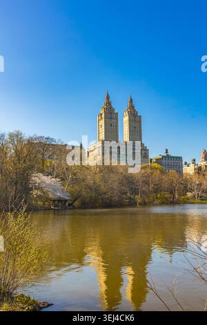 Ein senkrechter Blick auf die ikonischen Doppeltürme des luxuriösen Apartmentgebäudes von San Remo, das sich perfekt im ruhigen Wasser des Central Park Sees spiegelt Stockfoto