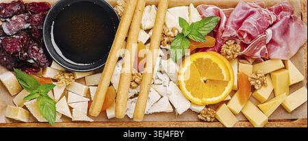 Essen, Eine schön gestaltete Käse- und Wurstplatte bietet eine Auswahl an Käse, Wurstwaren, Obst, Nüssen und Honig. Perfekt für Versammlungen o Stockfoto
