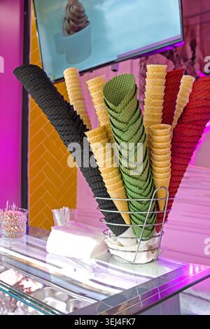 Farbenfrohe Waffeleiskegel werden in einem Kuchengeschäft ausgestellt Stockfoto
