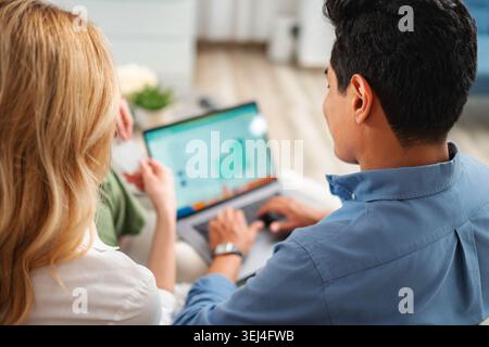 Paare, die online einkaufen mit Laptop und Kreditkarte Stockfoto