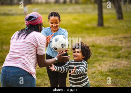 Liebe Familie, die Fußball spielt und Spaß im Freien hat Stockfoto