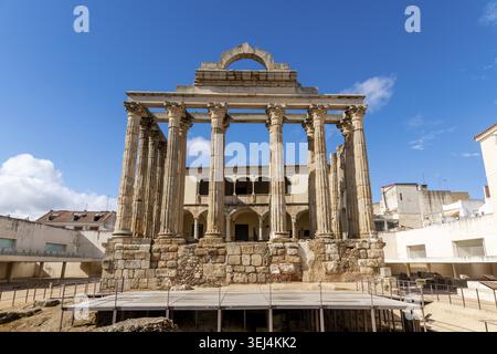 Die Vorderansicht des Teatro Romano in Merida zeigt gut erhaltene korinthische Säulen mit klarem blauen Himmel, umgeben von modernen Gebäuden Stockfoto