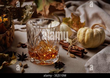 Whiskey auf Felsen mit Kürbissen und Herbstgewürzen. Stockfoto