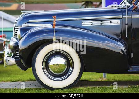 Oldtimer in Schwarz. Altes schwarzes Retro-Auto. Kotflügel und Vorderrad des Fahrzeugs. Seitenansicht. Selektiver Fokus Stockfoto