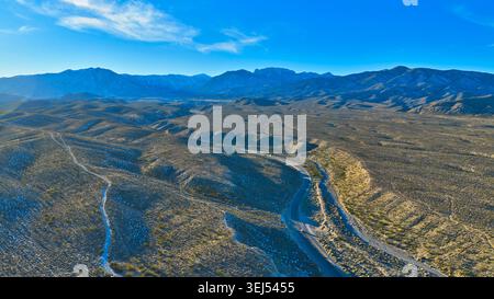 Nevada Desert Road und Mt. Charleston Foothills unter klarem blauem Himmel Stockfoto