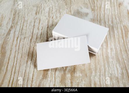 Leere Visitenkarten mit sanften Schatten auf hellem hölzernem Hintergrund. Vorlage für ID Stockfoto