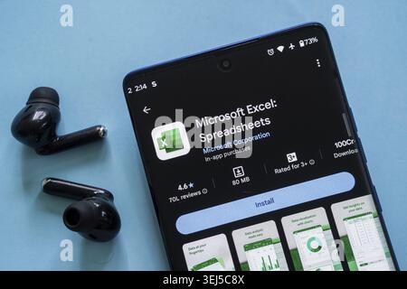 Dhaka, Bangladesch 23. August 2025: Die Download-Seite der Microsoft Excel-App wird auf einem Smartphone mit Ohrstöpseln in der Nähe angezeigt Stockfoto