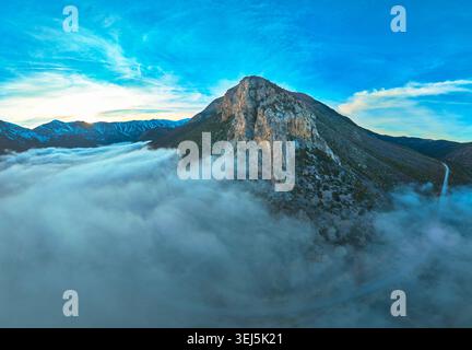 Bergpanorama des Mount Charleston über Wolken mit dramatischem Berg und gewundenen Straßen Stockfoto