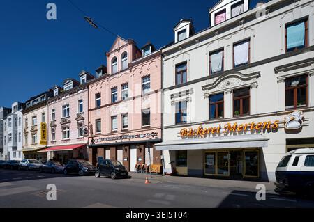 Köln, Deutschland 26. Mai 2026: Sonniger Straßenblick auf die Kölner Landmannstraße mit kunstvollen Fassaden aus dem 19. Jahrhundert, einer Bäckerei und lokalen Restaurants. Stockfoto