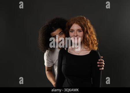 Junger Mann, der hinter der Frau steht und eine liebevolle Beziehung ausdrückt Stockfoto