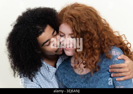 Junger Mann küsst die Wange der Frau, zeigt Zuneigung und enge Beziehung Stockfoto