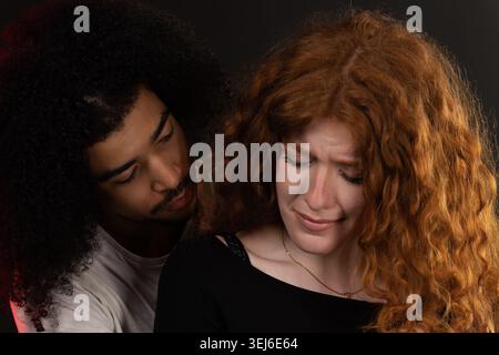 Ein junger Mann tröstet eine traurige Frau, die weint, Einfühlungsvermögen zeigt und Unterstützung in einer Beziehung zeigt Stockfoto