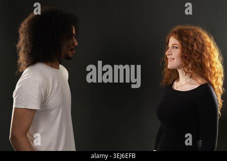 Ein junges, vielfältiges Paar, das sich ansieht und einen glücklichen Moment teilt Stockfoto