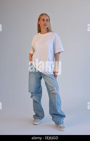 Ganzkörperaufnahme Einer Trendigen Frau Mit Gerissener Jeans Und Übergroßem Shirt In Der City Environment Stockfoto