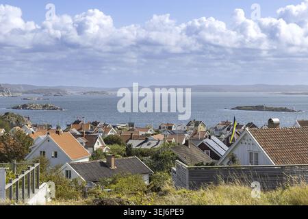 Hoher Blick auf die Insel Stora Dyron an der Küste von Tjorn, Schweden, mit roten Ziegeldächern, weißen Häusern, umgeben vom Meer, unter einem klaren blauen Himmel Stockfoto