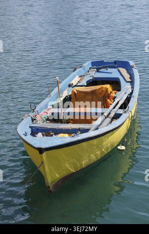 Altes gelbes Holzruderboot auf dem Wasser. Vertikale Aufnahme Stockfoto