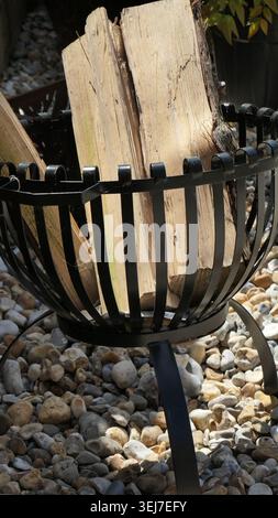 Nahaufnahme eines Gartenholzbrenners im Freien mit Holzstämmen im Inneren. Stockfoto