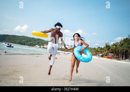 Reines Glück. Ein junges, vielseitiges, multiethnisches Paar genießt jeden Moment ihres tropischen Urlaubs Stockfoto