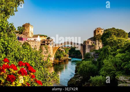 Eine alte Steinbrücke über den türkisfarbenen Neretva Fluss in der historischen Stadt Mostar in Bosnien und Herzegowina Stockfoto