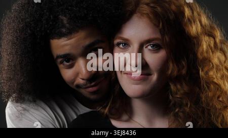Vielfältige junge Paare, die sich umarmen, miteinander und Verbundenheit repräsentieren Stockfoto