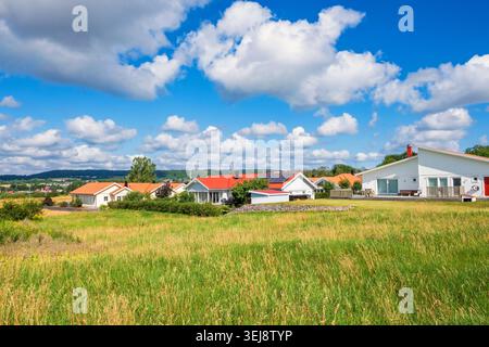 Blick auf eine Wohngegend mit Einfamilienhäusern durch eine Grünfläche im Sommer Stockfoto