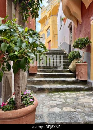 Malerischer Blick durch eine enge Straße in Positano, Italien, mit traditionellen Gebäuden, Vintage-Laterne und einem Blick auf den Strand und das türkisfarbene Meer Stockfoto