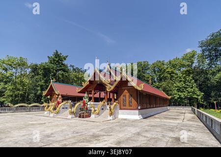 Dok Kham Tai, Phayao, Thailand - 28. Mai 2026: Wat Chaloem Phra Kiat (Wat San Pa Fang), Holzsaal mit goldener Naga und rotem Dach. Stockfoto