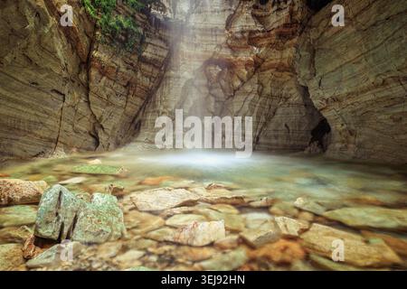 Trollkyrkja, Norwegen - 15.08.2023: Atemberaubender unterirdischer Wasserfall fällt in einen kristallklaren Pool in einer Marmorhöhle. Stockfoto
