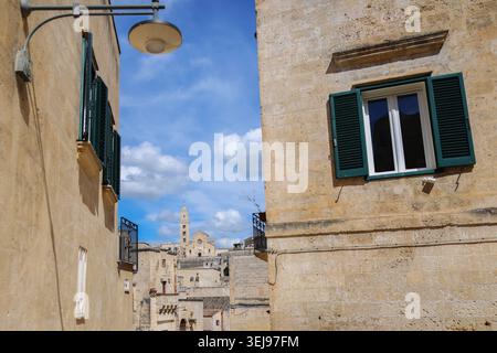 Malerischer Blick auf die historische italienische Stadt durch eine enge Steinstraße in Matera, sonnige mediterrane Atmosphäre und zeitlose europäische Architektur. Stockfoto