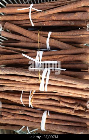 Haufen frischer Zimtrindenbündel auf einem lokalen Markt. Natürliches Kräutergewürz, gesundes kulinarisches Aroma Kochzutat. Stockfoto