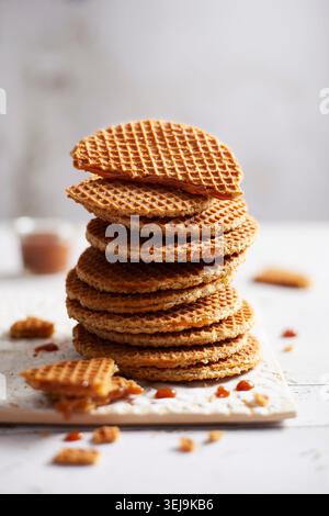 Nahaufnahme des Stilllebens eines hohen Stapels traditioneller niederländischer Stroopwafels auf einer weißen Platte. Die dünnen Waffelkekse mit ihren charakteristischen Wabenpas Stockfoto