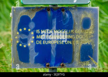Altes und etwas beschädigtes Schild mit dem Hinweis, dass ein bestimmtes Projekt teilweise von der Europäischen Union finanziert wird Stockfoto