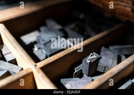 Vintage-Buchdruckblöcke aus Metall, die in einer Holzschublade angeordnet sind, mit dem Buchstaben „y“ sichtbar Stockfoto