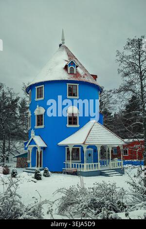 NAANTALI, FINNLAND - 27.12.2023: Das ikonische blaue Moomint House, das im Winterschnee im Moominworld (Muumimaailma) Freizeitpark liegt. Stockfoto