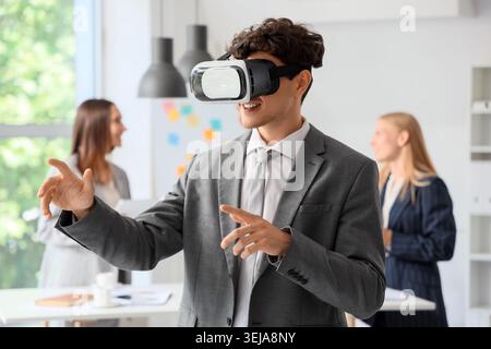 Junger Geschäftsmann mit VR-Brille im Büro Stockfoto