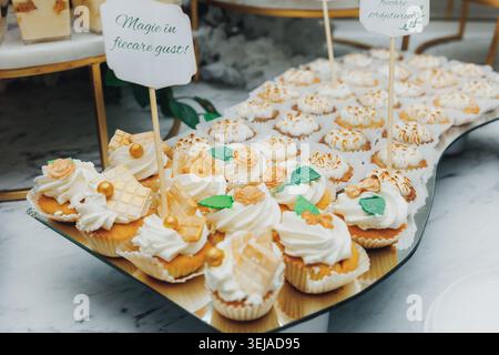 Zarte Cupcakes mit Creme und essbaren Blumen Stockfoto