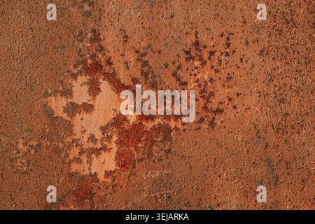 Detaillierte Makroaufnahme aus stark korrodiertem Eisenblech mit sattem orangenem und braunem Rost. Robuste industrielle Textur für Grafikdesign und 3D-Grafiken. Stockfoto