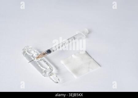 Medizinische Spritze, Glasampule und Mulltupfer auf weißem Hintergrund für die Injektionsvorbereitung Stockfoto