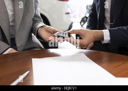 Die Schlüsselübergabe beim Kauf eines neuen Fahrzeugs in einem Autohändler Stockfoto